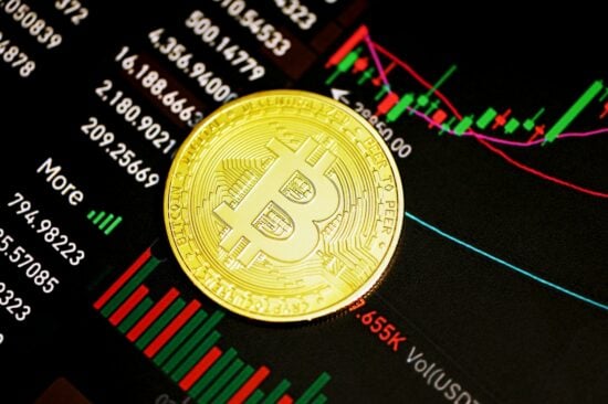 A bitcoin on the surface of a trading chart.